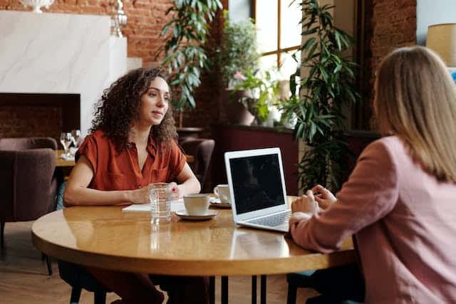 Two people at a coffee shop doing an interview.