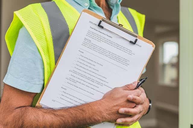An inspector holding a checklist on a clipboard.